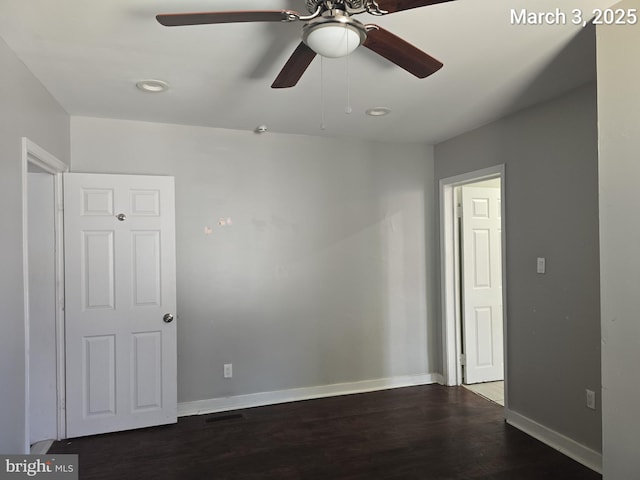 spare room with baseboards, wood finished floors, and a ceiling fan