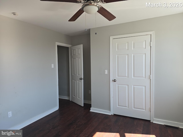 unfurnished bedroom featuring visible vents, baseboards, ceiling fan, and dark wood-style flooring