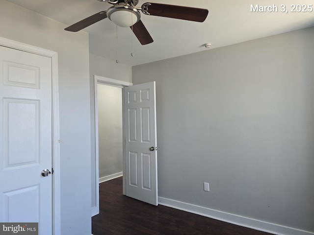 unfurnished bedroom featuring baseboards, dark wood finished floors, and a ceiling fan