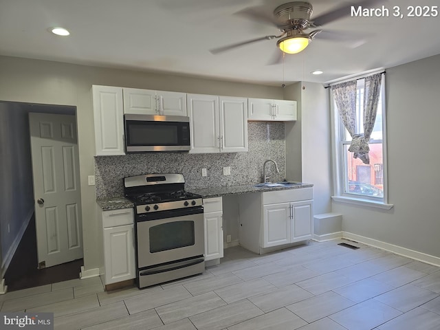 kitchen with white cabinetry, dark stone counters, tasteful backsplash, and appliances with stainless steel finishes