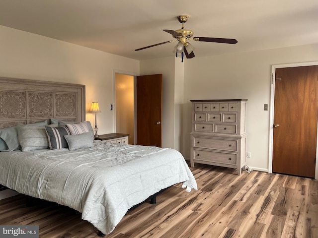 bedroom featuring a ceiling fan, wood finished floors, and baseboards