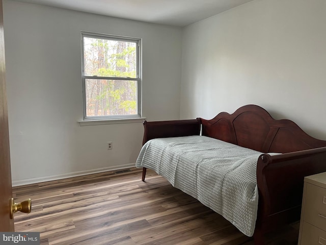 bedroom featuring baseboards and wood finished floors