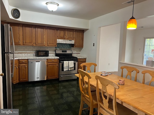 kitchen featuring visible vents, under cabinet range hood, appliances with stainless steel finishes, brown cabinetry, and light countertops