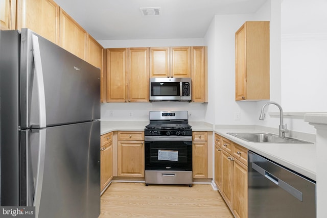 kitchen with a sink, stainless steel appliances, visible vents, and light brown cabinets