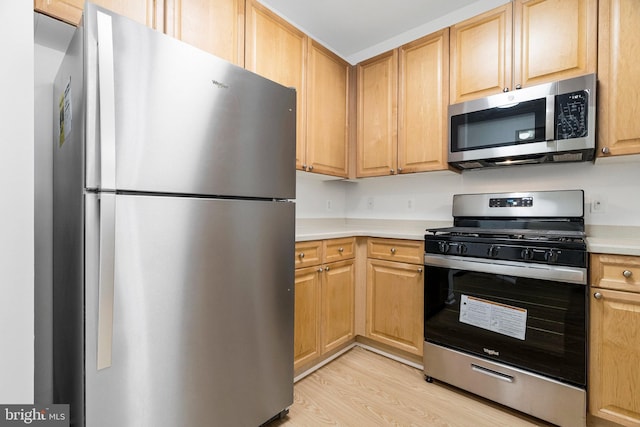 kitchen with light countertops, light brown cabinets, light wood-type flooring, and appliances with stainless steel finishes