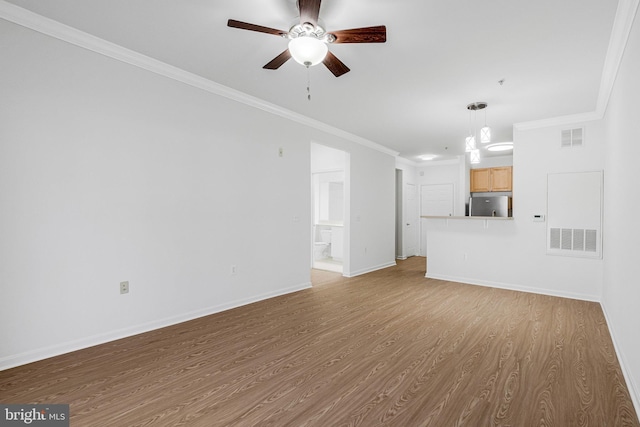 unfurnished living room with a ceiling fan, visible vents, wood finished floors, baseboards, and ornamental molding