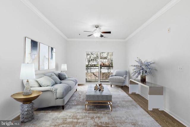 living area featuring baseboards, a ceiling fan, wood finished floors, and crown molding