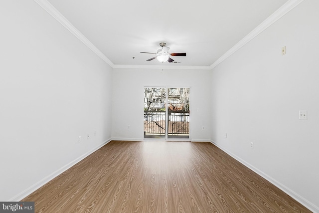 empty room with ceiling fan, wood finished floors, baseboards, and ornamental molding