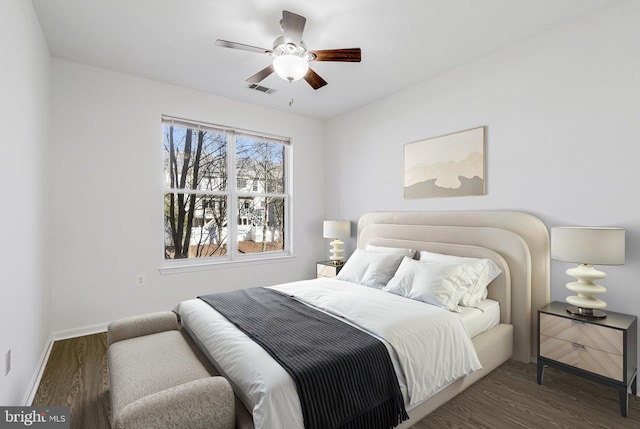 bedroom with visible vents, baseboards, wood finished floors, and a ceiling fan