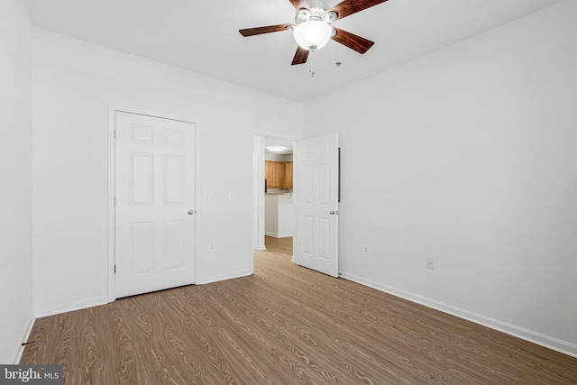 unfurnished bedroom with ceiling fan, baseboards, and wood finished floors