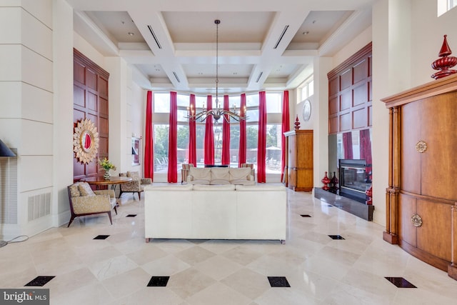 interior space with visible vents, coffered ceiling, beam ceiling, a towering ceiling, and a notable chandelier