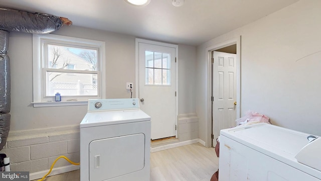 washroom featuring laundry area, washing machine and dryer, and light wood-style floors