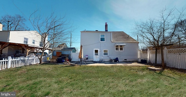 back of property with a fenced backyard, a yard, a shingled roof, crawl space, and a patio area