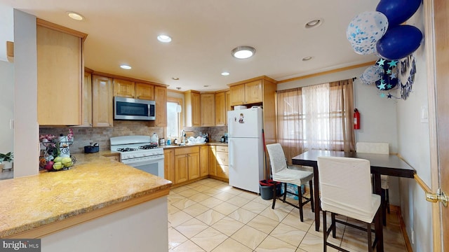 kitchen featuring decorative backsplash, white appliances, recessed lighting, and light brown cabinets