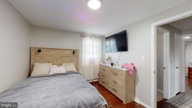 bedroom with baseboards and dark wood finished floors