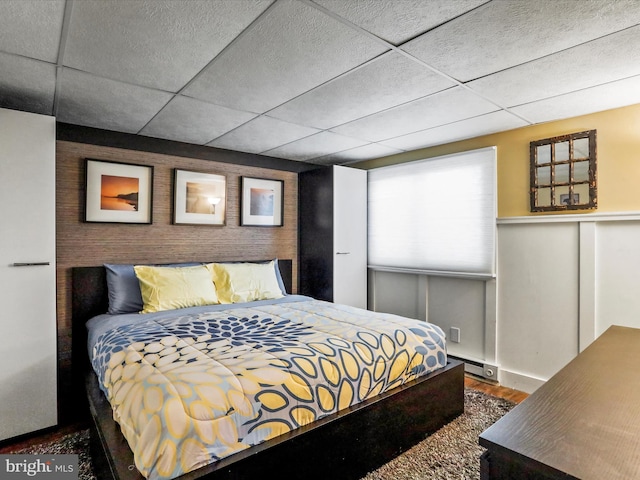 777 Timber Ln, Berkeley Springs, WV 25411 - bedroom featuring a baseboard heating unit, a drop ceiling, and wood finished floors