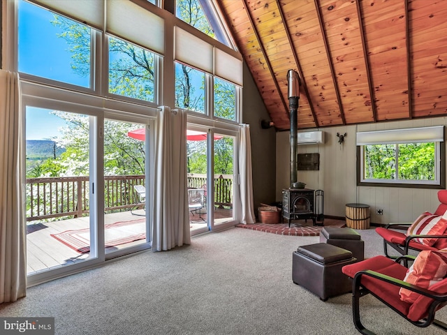 777 Timber Ln, Berkeley Springs, WV 25411 - carpeted living room featuring a wood stove, beamed ceiling, high vaulted ceiling, an AC wall unit, and wood ceiling