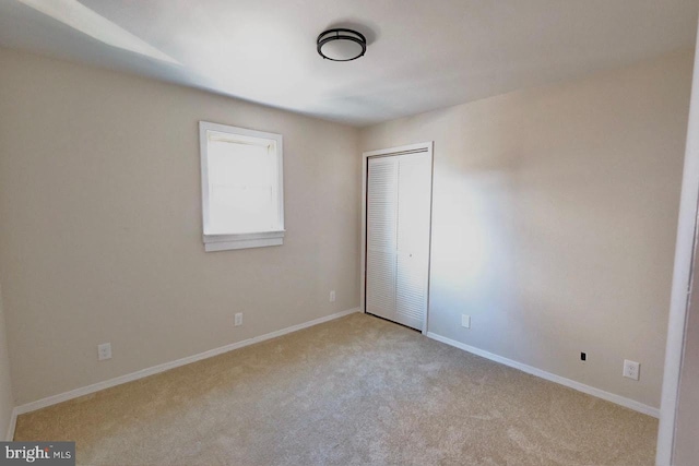 unfurnished bedroom featuring a closet, baseboards, and carpet