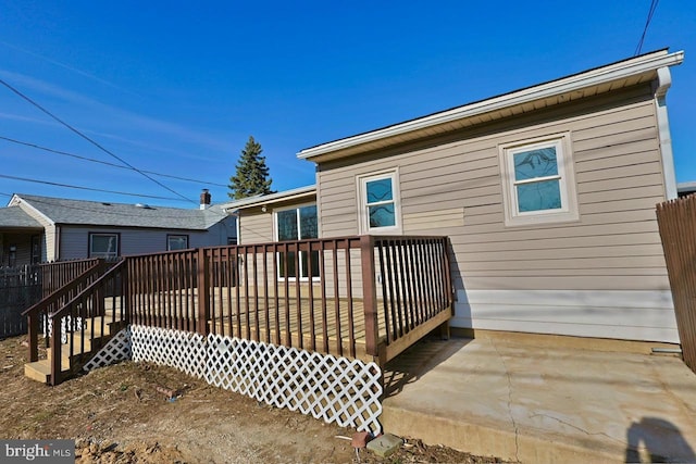 rear view of house with a wooden deck and a patio