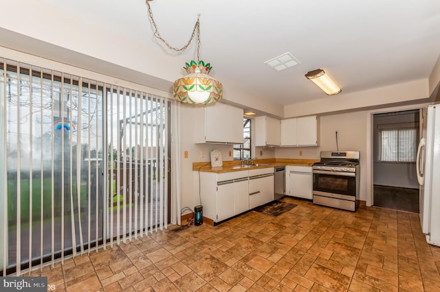 kitchen featuring visible vents, light countertops, appliances with stainless steel finishes, white cabinets, and a sink