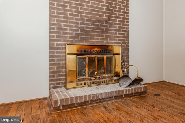 interior details with baseboards, wood finished floors, and a fireplace