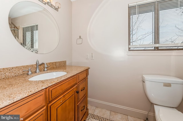 bathroom featuring baseboards, toilet, vanity, and tile patterned flooring