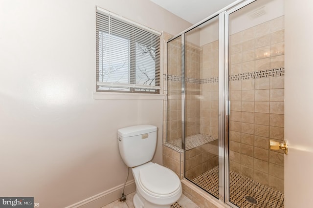 bathroom with tile patterned floors, toilet, baseboards, and a stall shower