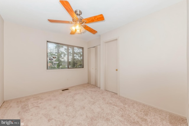 unfurnished bedroom with visible vents, carpet floors, and multiple closets