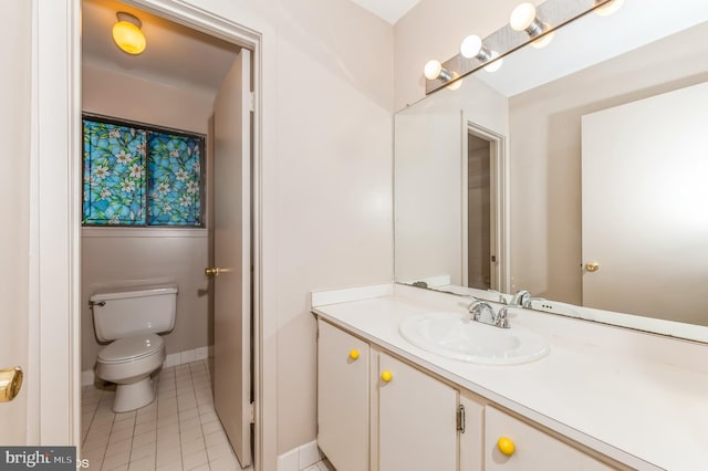 bathroom featuring vanity, tile patterned floors, toilet, and baseboards