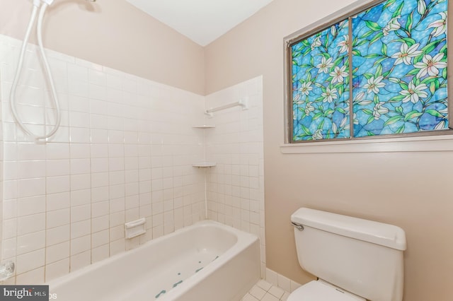 bathroom featuring bathing tub / shower combination, toilet, baseboards, and tile patterned floors