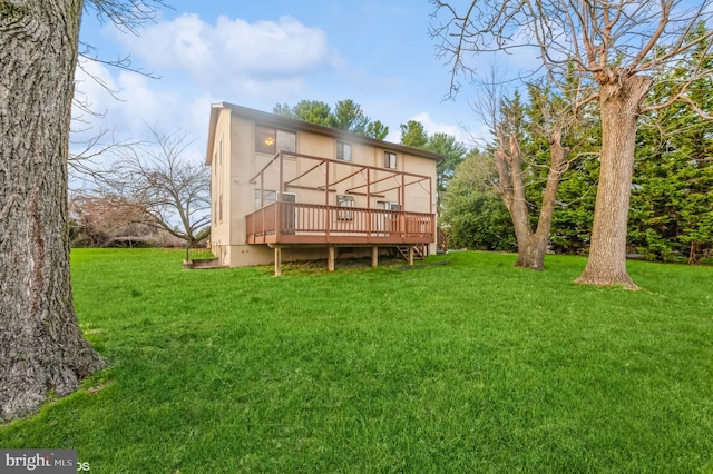 back of property with a yard and a wooden deck