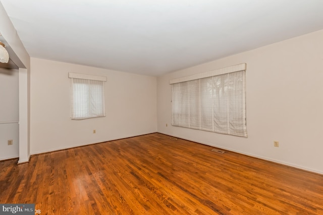 spare room with wood finished floors and visible vents