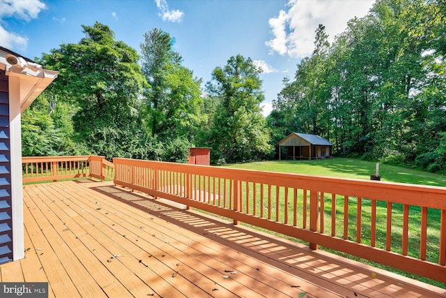 wooden deck with an outdoor structure and a lawn