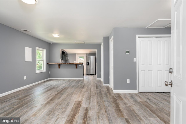 unfurnished living room with visible vents, baseboards, and wood finished floors