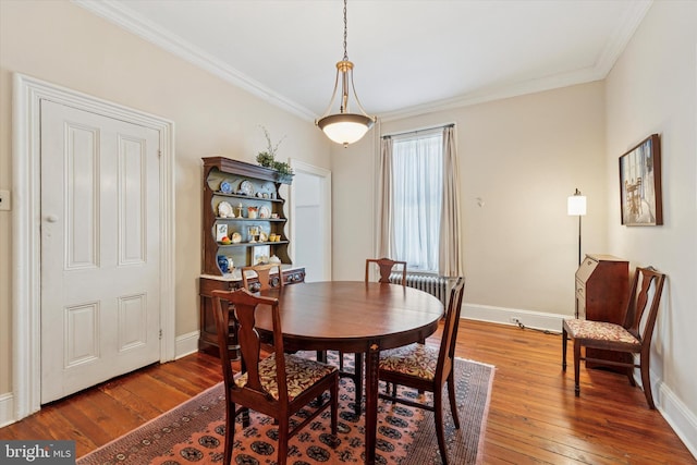 dining space with hardwood / wood-style flooring, baseboards, and ornamental molding