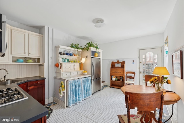 kitchen with a sink, open shelves, dark countertops, and stainless steel appliances