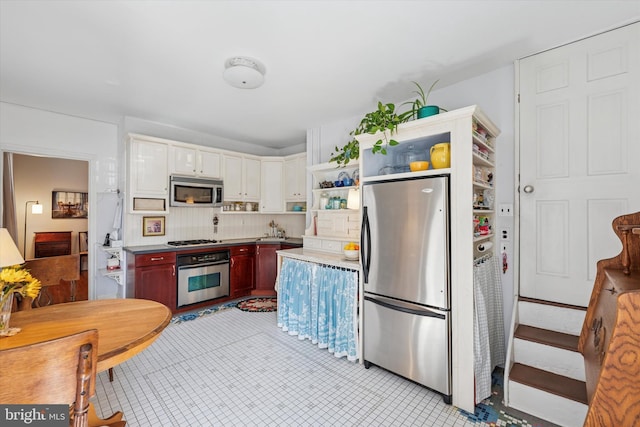 kitchen featuring dark brown cabinets, backsplash, stainless steel appliances, and open shelves