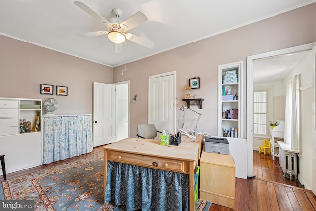 home office featuring crown molding, a ceiling fan, and wood-type flooring