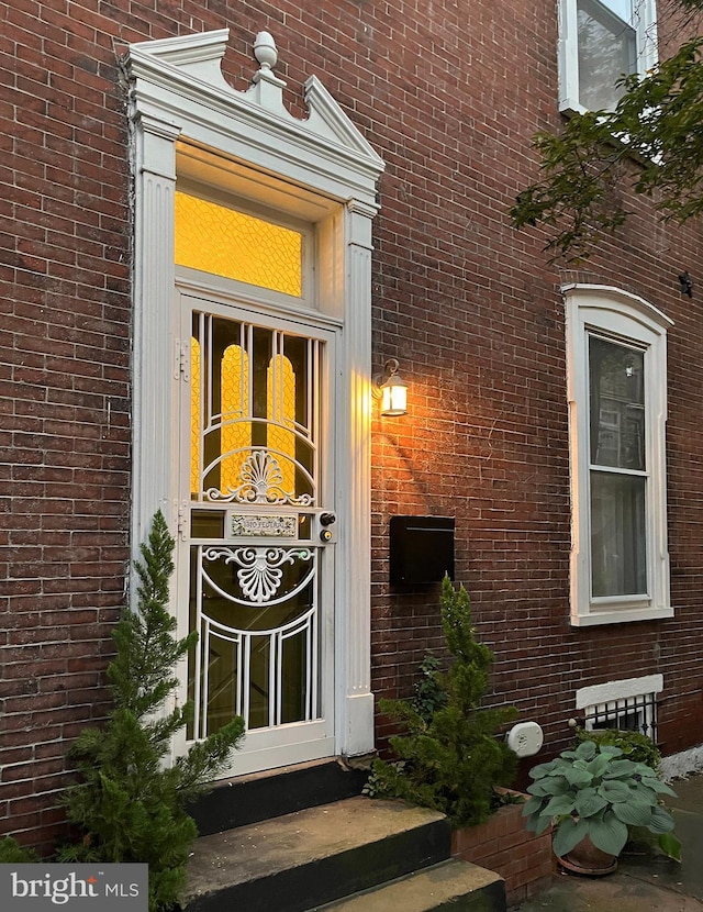 view of exterior entry featuring brick siding