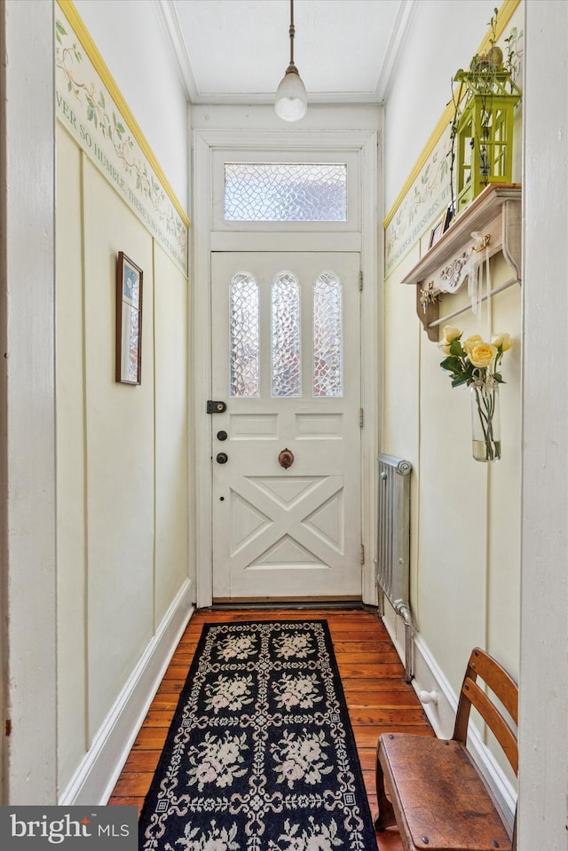 doorway featuring wood finished floors and ornamental molding