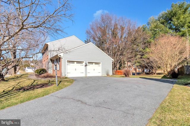 view of side of property featuring aphalt driveway and an attached garage