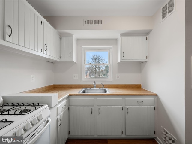 kitchen featuring a sink, visible vents, and white gas range oven