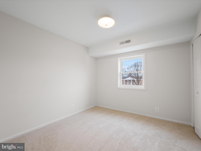 unfurnished room with baseboards, visible vents, and light carpet