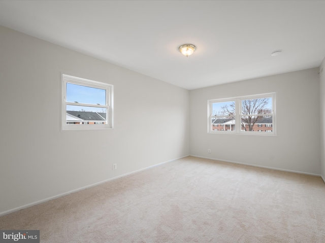 empty room with light colored carpet and baseboards