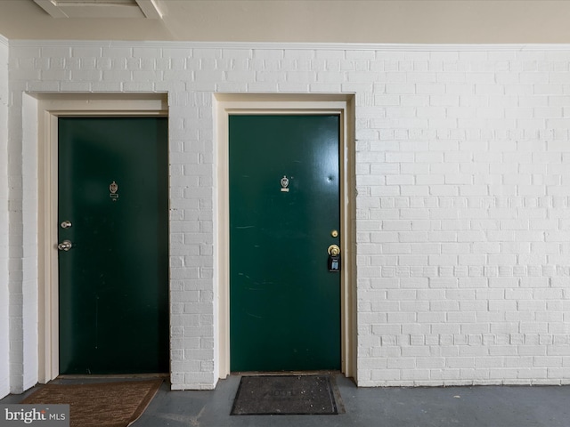 entrance to property featuring brick siding