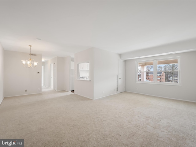 unfurnished living room with baseboards, visible vents, light carpet, and an inviting chandelier