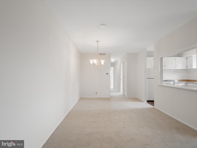 unfurnished dining area with an inviting chandelier, light colored carpet, visible vents, and baseboards