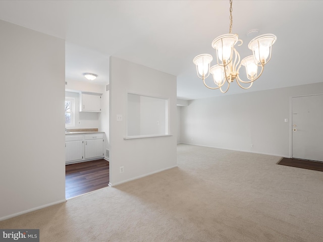 interior space with baseboards, carpet, and an inviting chandelier