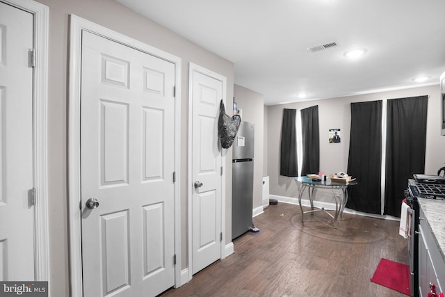 interior space with visible vents, baseboards, and dark wood-style flooring