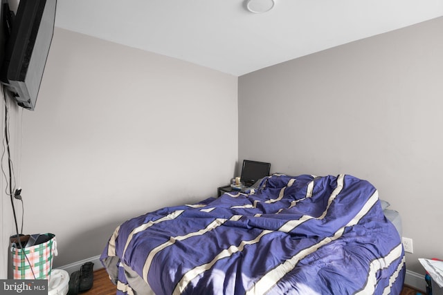 bedroom with baseboards and wood finished floors